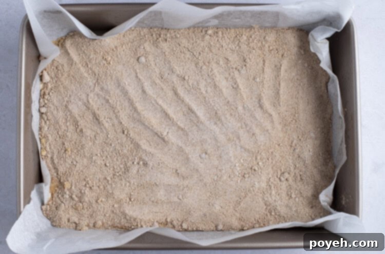 Bottom layer of vegan coffee cake in 9x13 baking dish with parchment paper