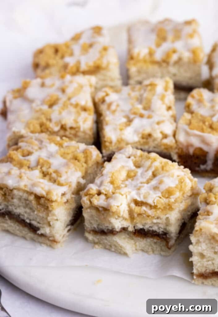 Squares of vegan coffee cake on a white plate, showing the beautiful streusel and glaze