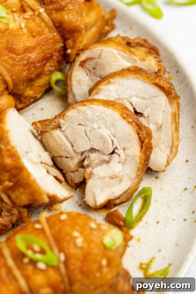 Beautifully sliced chicken chashu arranged on a plate, garnished with fresh chopped scallions, showcasing its tender interior and golden skin.