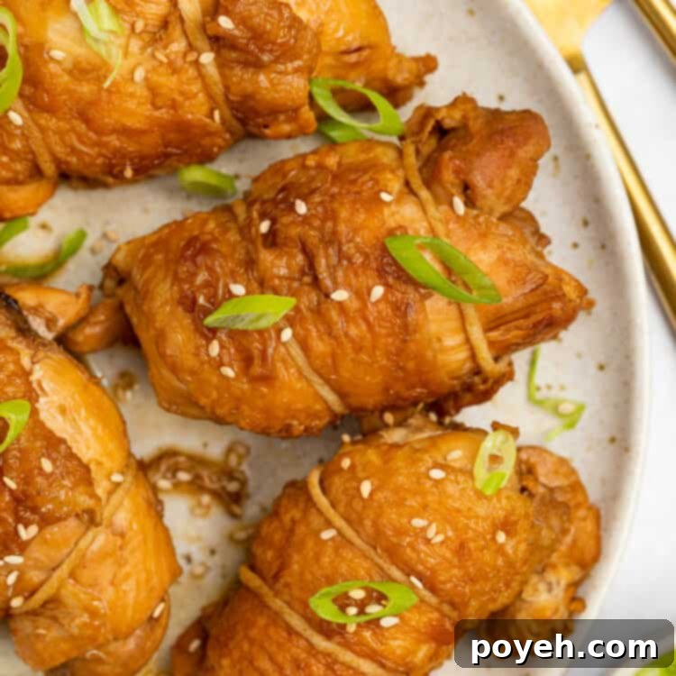 Glistening chicken chashu slices on a plate, topped with green scallions and sesame seeds, ready to be enjoyed.
