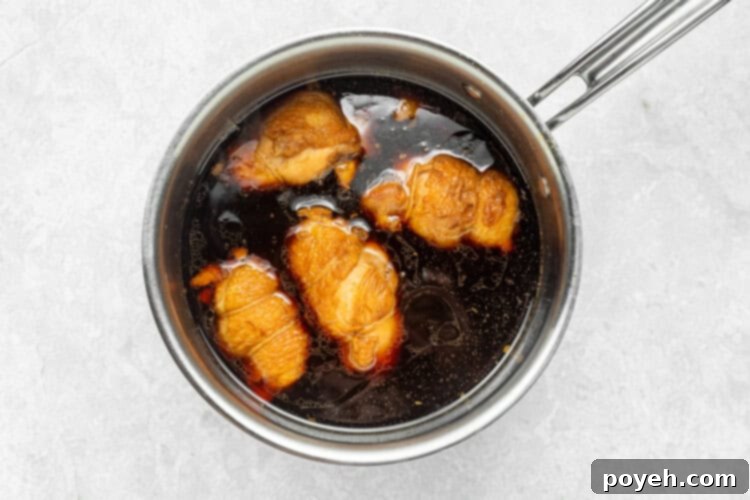 Step 4: Chicken chashu simmering in the flavorful braising liquid.