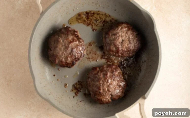 Cooked buffalo burger patties in large skillet