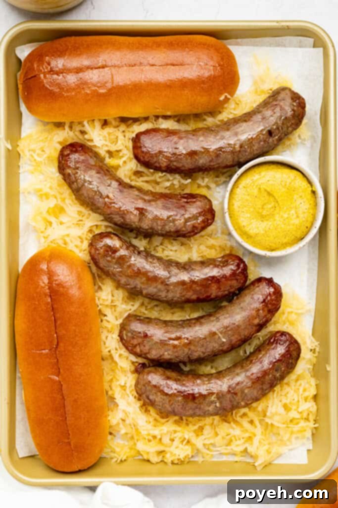 Air fryer brats beautifully arranged on a baking sheet, accompanied by classic sauerkraut, tangy mustard, and soft brioche buns, ready for serving.
