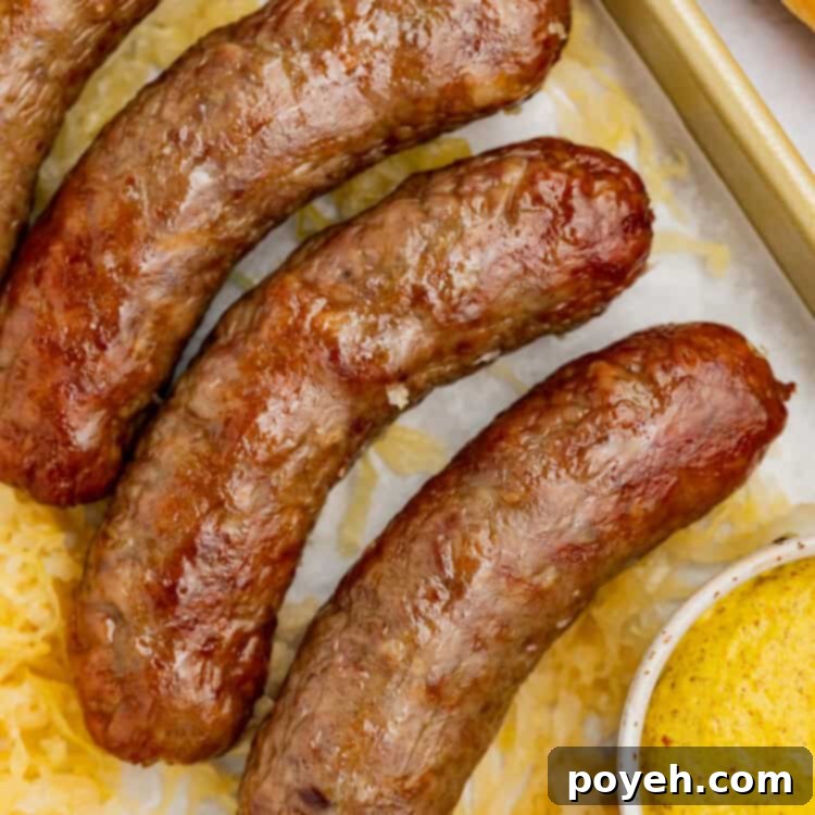 Close-up image of perfectly cooked air fryer brats with mustard on the side, presented invitingly on a dark background.
