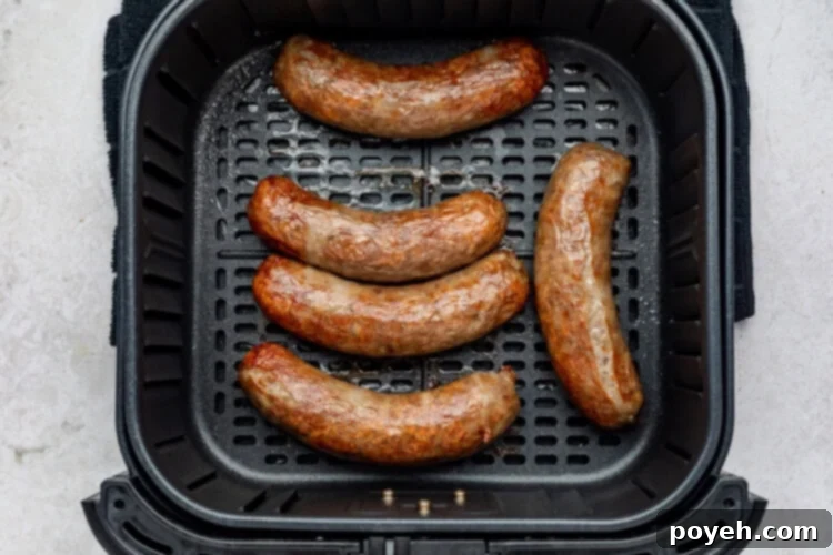 Air fryer brats process photo showcasing perfectly cooked, golden-brown brats ready to be removed from the air fryer basket.