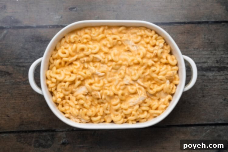 Overhead view of macaroni and cheese in a casserole dish on a wooden background.