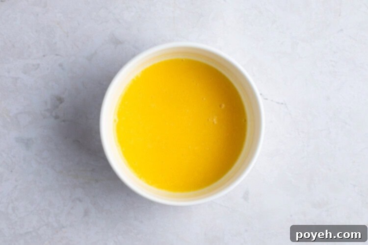 Melted butter with egg in ramekin, thoroughly mixed.