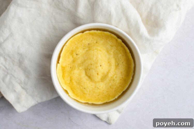 Microwaved keto English muffin in ramekin, firm and risen.