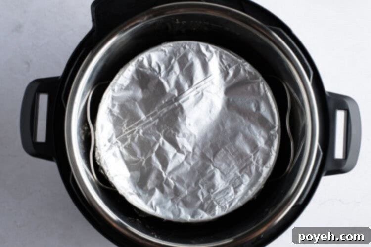 Instant Pot setup with water, trivet, and covered cornbread pan