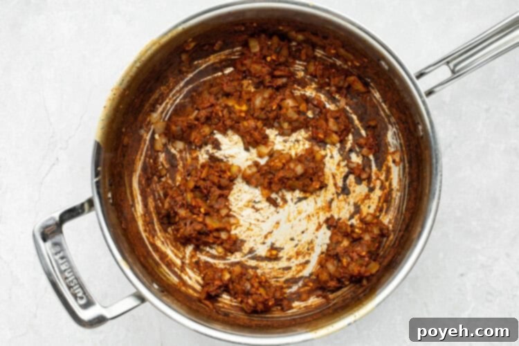 Deglazing the skillet with apple cider vinegar, scraping up flavorful browned bits.