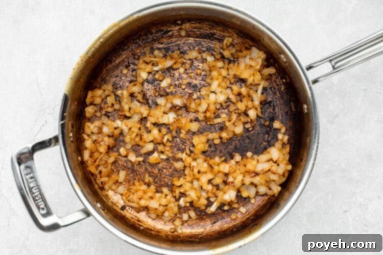 Caramelizing chopped onions in a skillet until golden brown and sweet.
