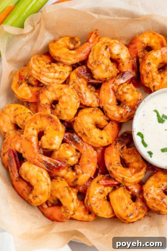 Perfectly cooked buffalo shrimp on a white plate, ready to be enjoyed with a side of ranch dressing.