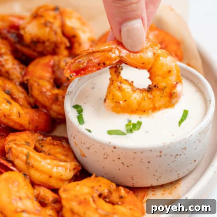 buffalo shrimp being dipped into a bowl of ranch dressing