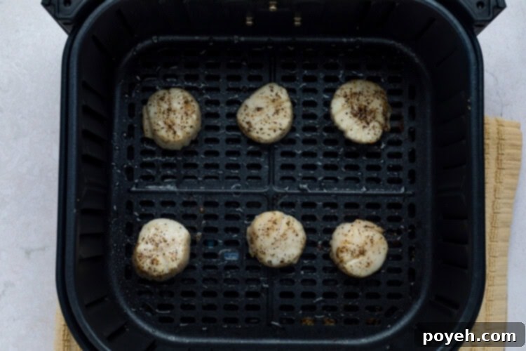 Cooked air fryer scallops with a lemon wedge.