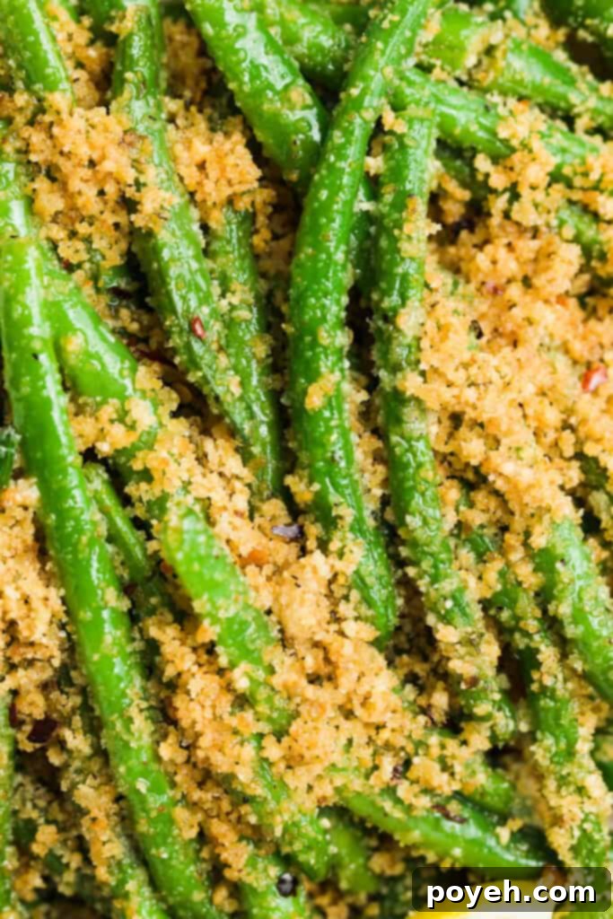 Garlicky Italian Green Beans 2 Overhead close-up image of a vibrant plate of Italian green beans, perfectly coated in toasted breadcrumbs and parmesan, ready to be served.