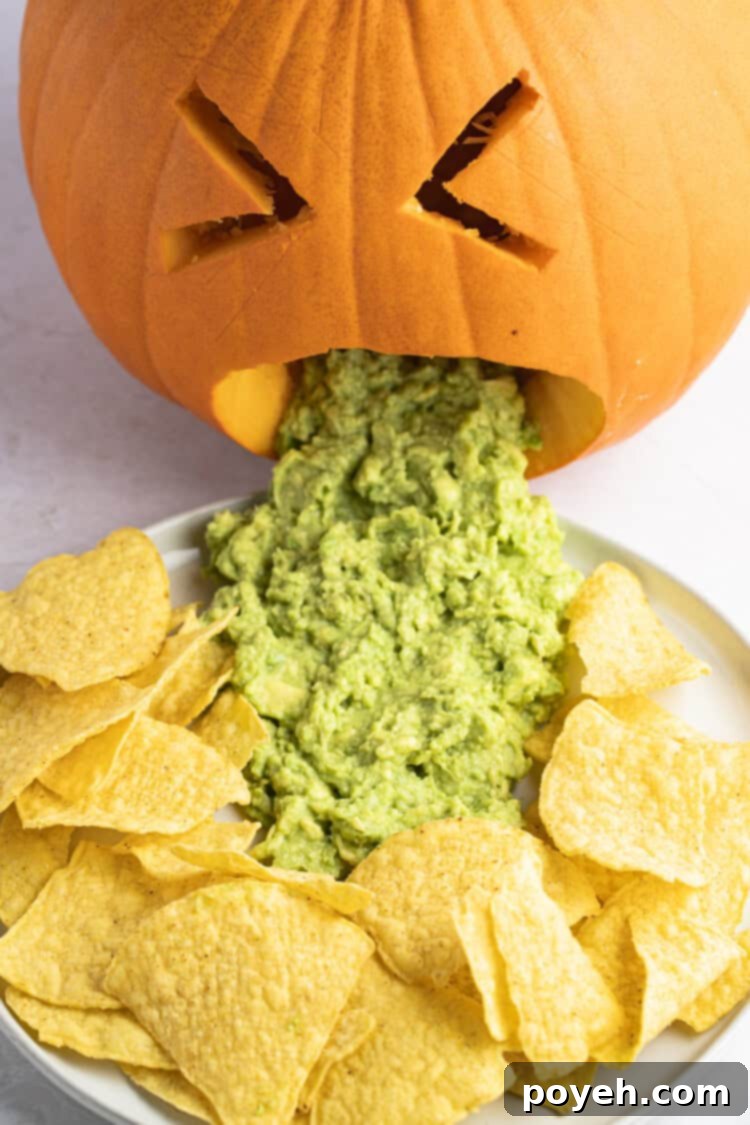 Close-up of a puking pumpkin with guacamole and tortilla chips