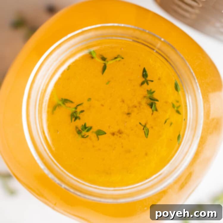 Overhead image of Instant Pot turkey stock with fresh herbs on the side, ready to be strained