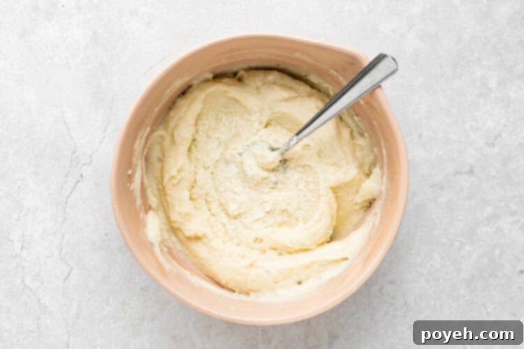 mashed potatoes in a bowl with dehydrated potatoes being added