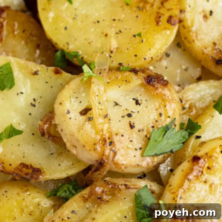 Closeup view of smothered potatoes in a cast iron skillet, golden brown and perfectly cooked.