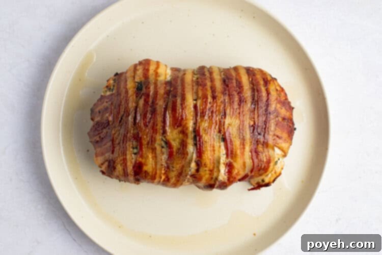 Cooked bacon wrapped turkey breast on plate