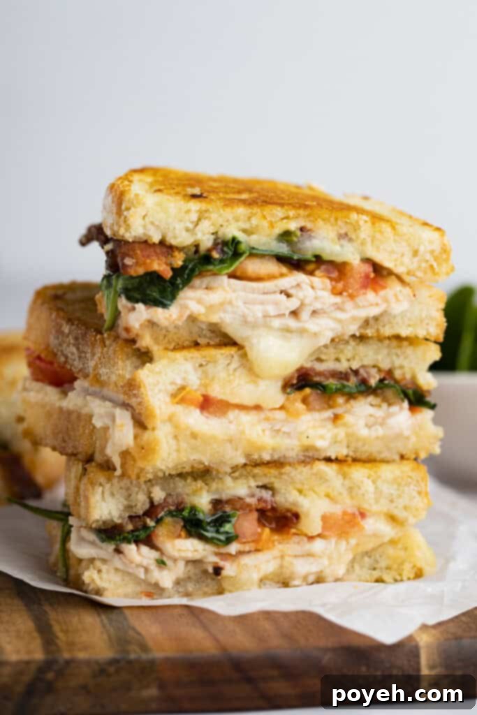 Three halves of a turkey melt stacked on top of each other 