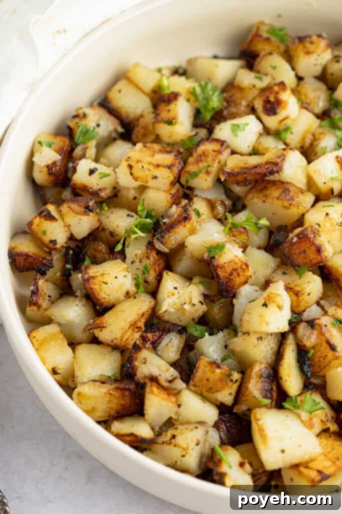 Southern fried potatoes in a large bowl, garnished with fresh herbs
