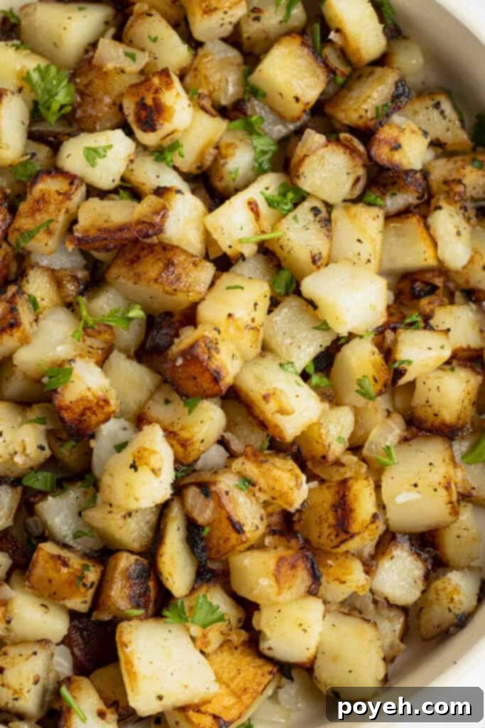 Closeup view of southern fried potatoes in a large bowl, showing crispy texture