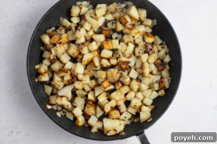 Pan-fried potatoes and onions in large cast iron skillet, covered