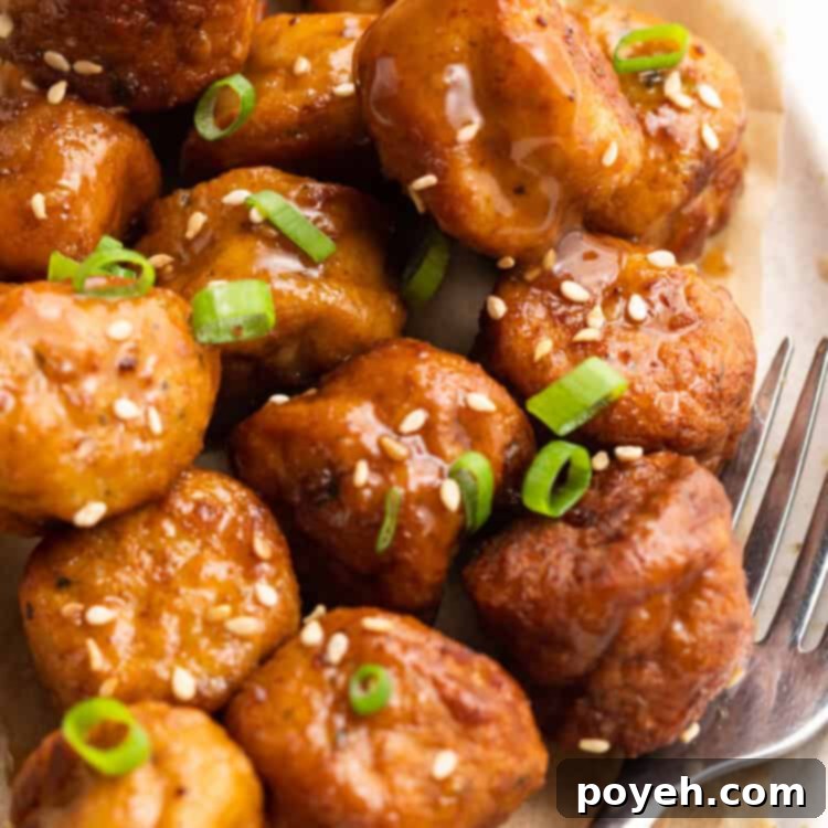 Frozen meatballs in air fryer on a plate with a fork, ready to be eaten.