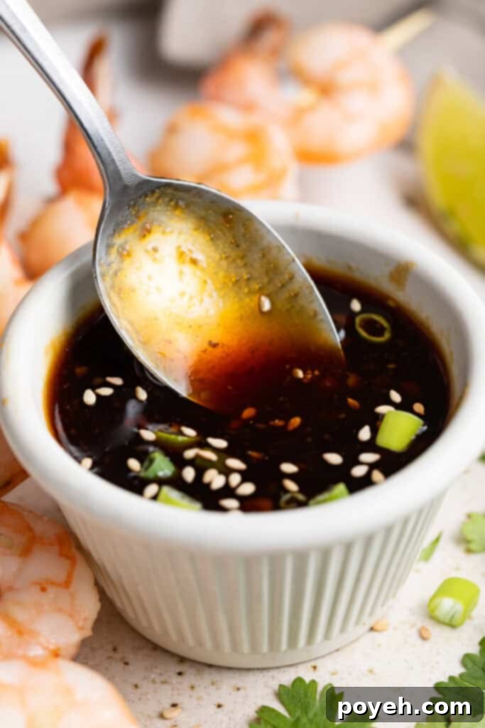 Delicious keto teriyaki sauce in a small dish with a wooden spoon, showcasing its rich texture and color, ready for use as a dipping sauce, marinade, or glaze.