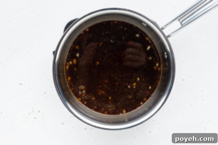 All ingredients for keto teriyaki sauce (except xanthan gum) simmering gently in a small saucepan, releasing their aromatic flavors, ready for thickening.