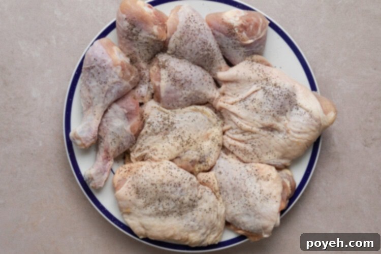 Seasoning chicken pieces with salt and pepper for Instant Pot Chicken Paprikash.