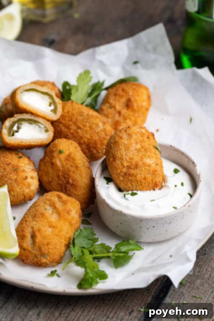 Air Fried Crispy Frozen Jalapeño Poppers 2 air fryer frozen jalapeno poppers on a plate and being dipped into cilantro lime dipping sauce
