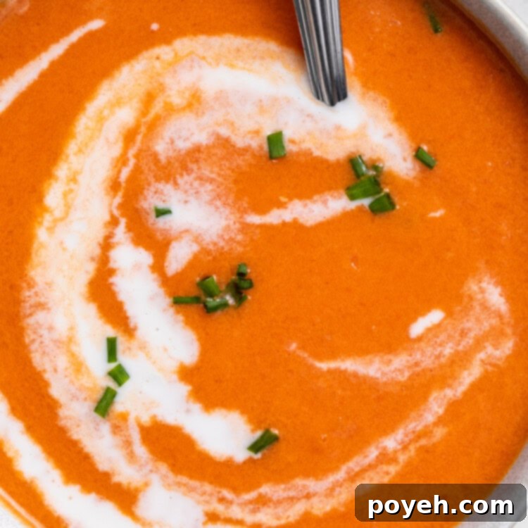 close-up overhead image of gluten-free tomato soup in a bowl with heavy cream swirled on top