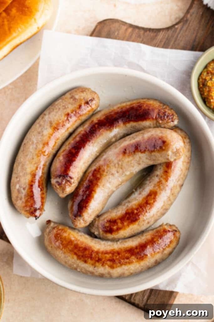 Overhead view of Instant Pot brats in a white bowl on a wooden serving paddle.