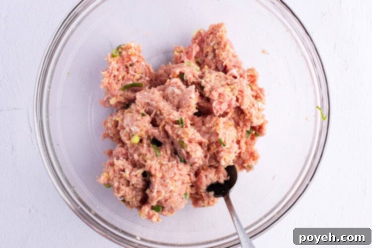 Ingredients for Asian turkey meatballs in a glass mixing bowl.