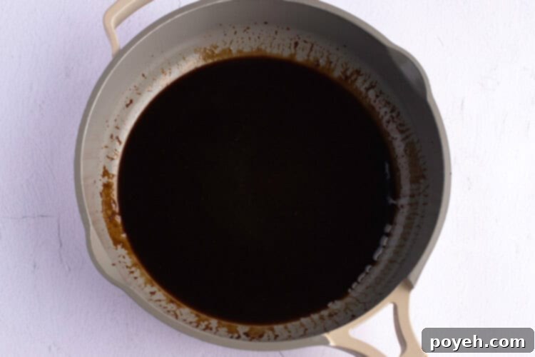 Overhead view of the Asian turkey meatball sauce in a large skillet.