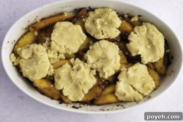 Keto peach cobbler in large white oval baking dish.