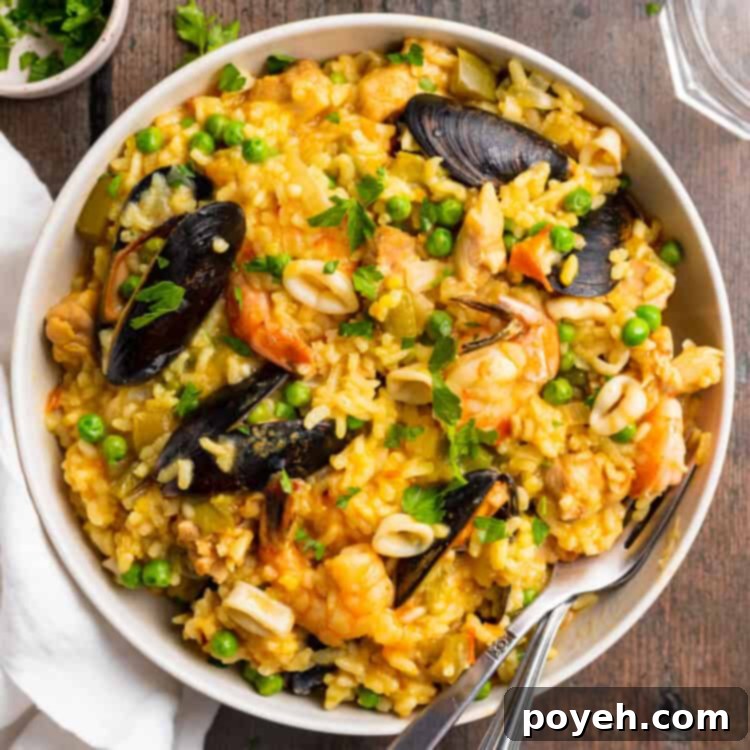 Overhead view of a plate of Instant Pot paella on a wooden tabletop.