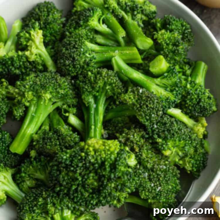 Overhead view of a bowl of sous vide broccoli on a dark tabletop.