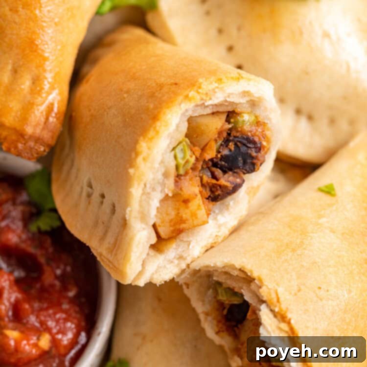 Overhead view of a pile of golden-brown baked vegan empanadas ready to be served.