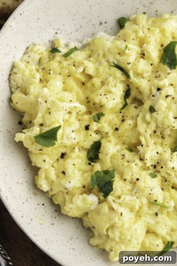 Overhead close-up view of Instant Pot scrambled eggs in a large white bowl with garnish.
