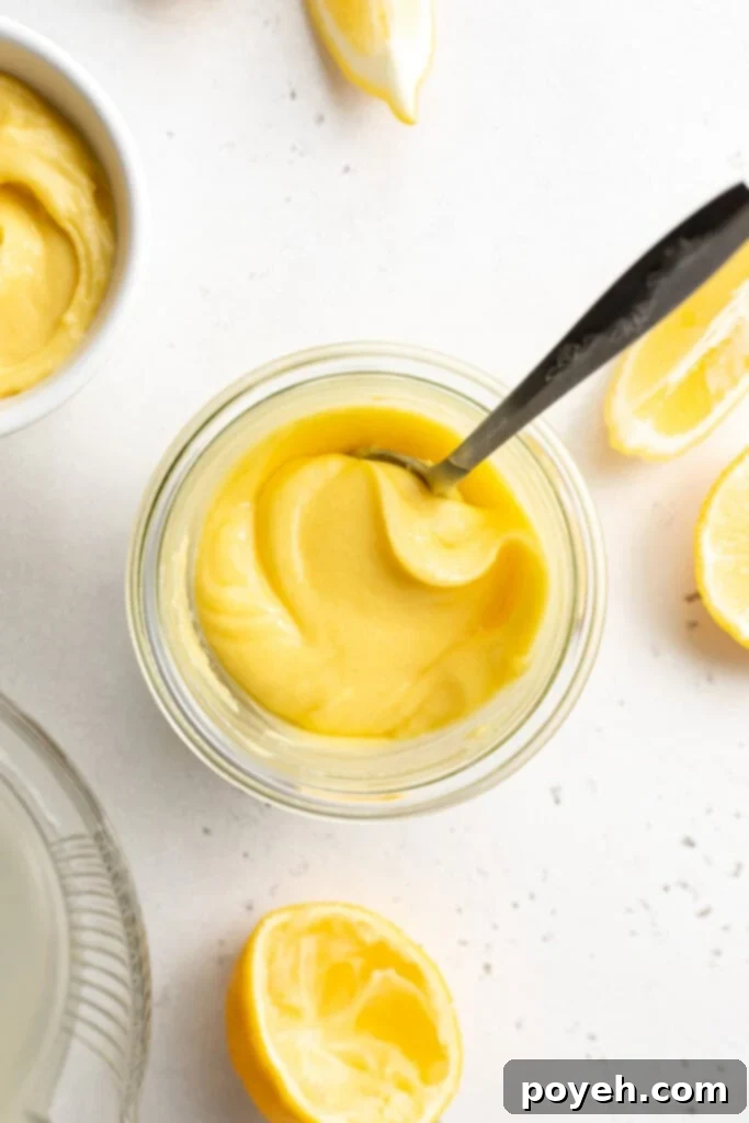 Overhead view of a glass of keto lemon curd with a spoon.