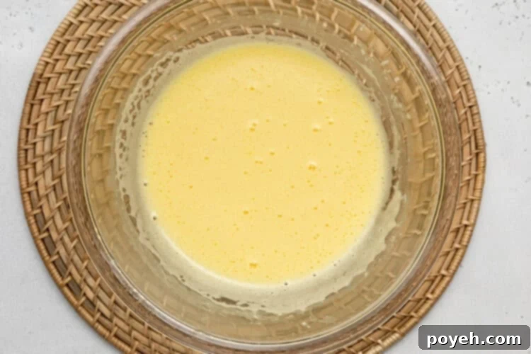 Overhead view of ingredients for keto lemon curd in a large glass bowl.