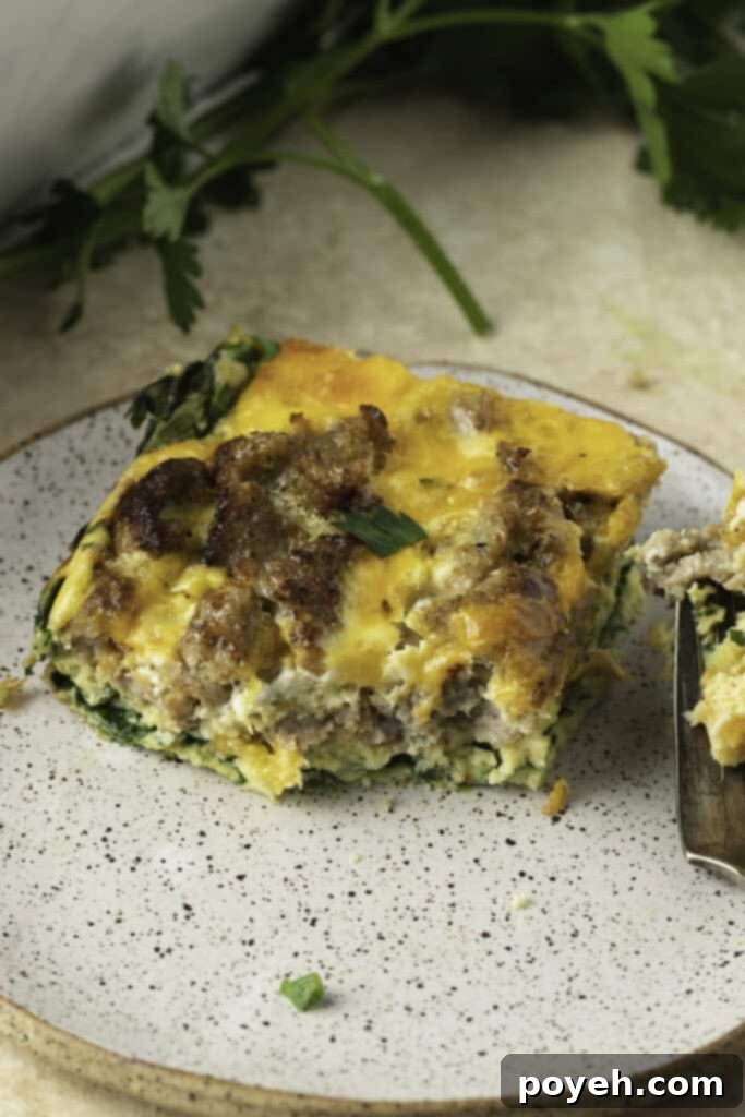 A square of keto breakfast casserole on a plate with a fork.