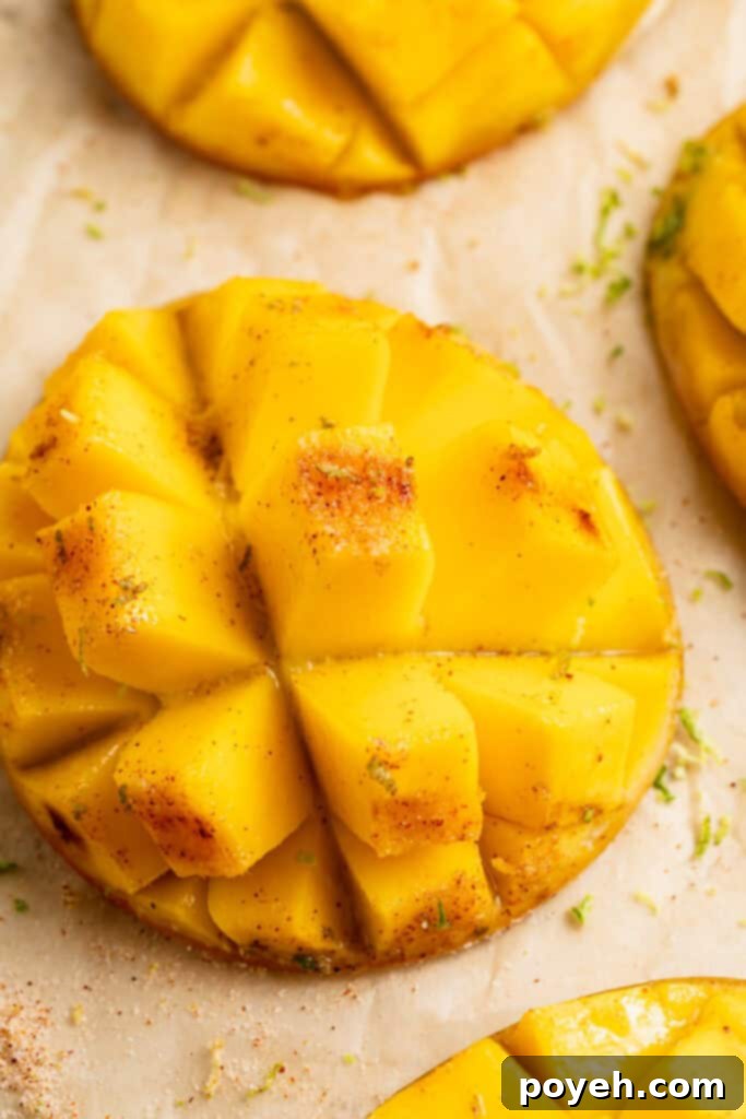 Close-up view of a cubed, grilled mango on a sheet of parchment paper, highlighting its tender texture and golden color, ready to be served or added to a dish.
