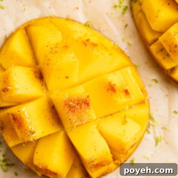 Close-up view of a cubed, grilled mango on a sheet of parchment paper, beautifully charred and seasoned.