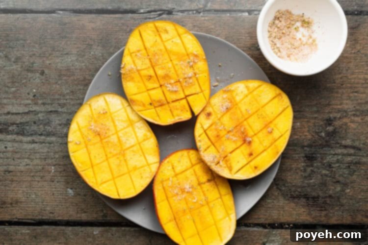 Grilled mango with chili-lime salt and fresh lime juice on a rustic plate on a wooden table, elegantly prepared for serving.