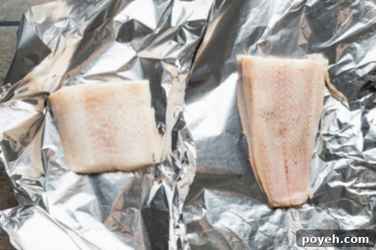 Seasoned cod fillets on foil.