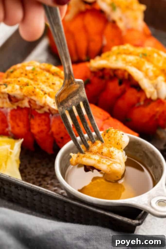 A piece of Instant Pot lobster tail meat on the end of a fork being dipped into drawn butter.